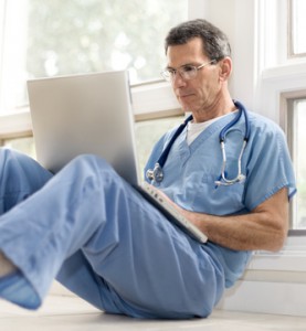 Doctor Reviewing His Notes on Laptop